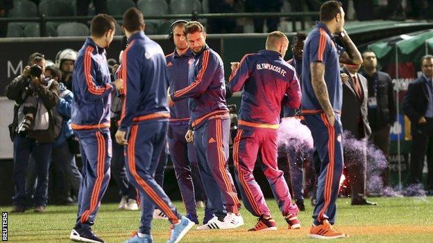 Olympiakos striker Alfred Finnbogason is hit by a flare