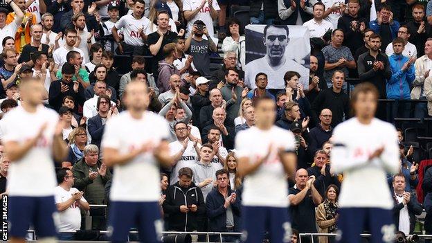 A Spurs fan holds up a flag of Jimmy Greaves