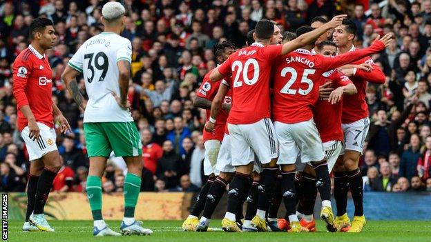 Players of Manchester United surround referee Craig Pawson