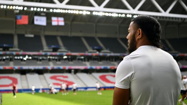 Manu Tuilagi looks out over Stade Pierre Mauroy with the England and Samoa flags hanging from the rafters