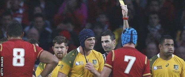 Referee Craig Joubert shows Australia lock Dean Mumm a yellow card against Wales