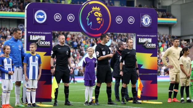 Players of Brighton & Hove Albion and Chelsea line up under the Rainbow Laces handshake board