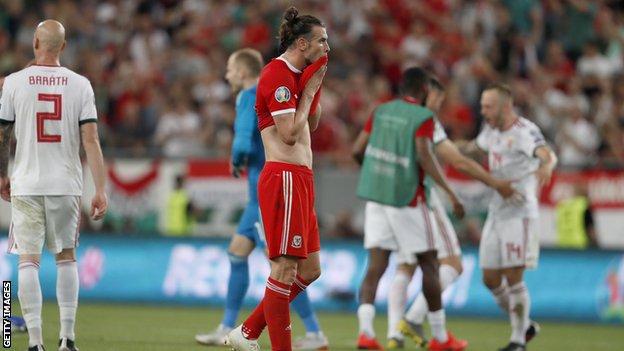 Wales forward Gareth Bale cuts a forlorn figure as Hungary celebrate victory