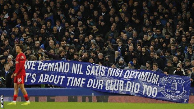 Everton fans hold up a banner demanding move of club owners