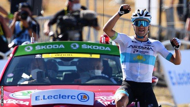 Alexey Lutsenko raises his arms in celebration after winning stage six of the 2020 Tour de France