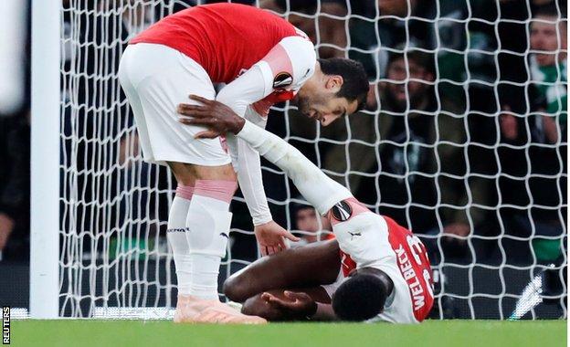 Arsenal's Henrikh Mkhitaryan with injured team-mate Danny Welbeck