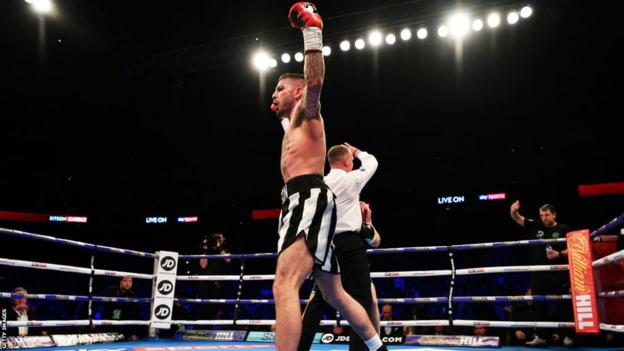 Lewis Ritson raises his arms in celebration