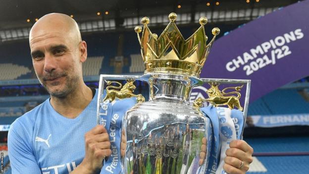 Manchester City-manager Pep Guardiola heeft de Premier League-trofee in handen na het winnen van de titel van 2021/22