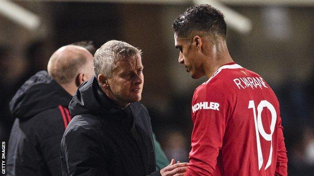 Raphael Varane discusses his injury with Ole Gunnar Solskjaer as he leaves the pitch against Atalanta