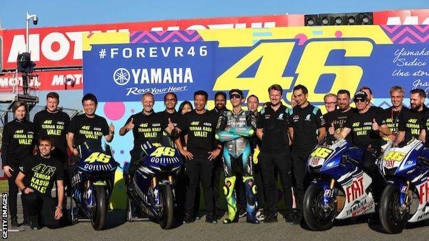 Valentino Rossi poses with his bikes and team members after his final MotoGP race