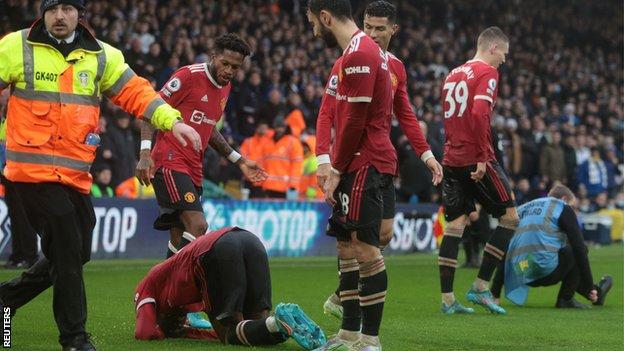 Anthony Elanga is down on the pitch after being struck by an object