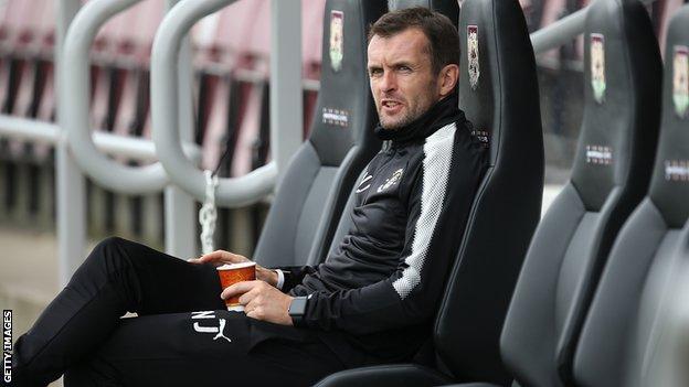Luton boss Nathan Jones takes his seat in the dugout before a friendly against Northampton in September