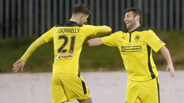 Jay Donnelly celebrates Cliftonville's second goal with scorer David McDaid who had earlier seen a penalty saved by Ryan Brown