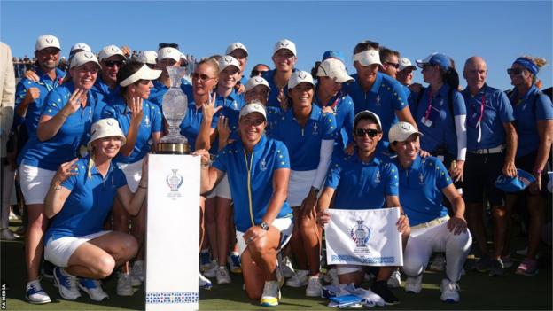 European team celebrating retaining the Solheim Cup by posing for a team photograph with the trophy