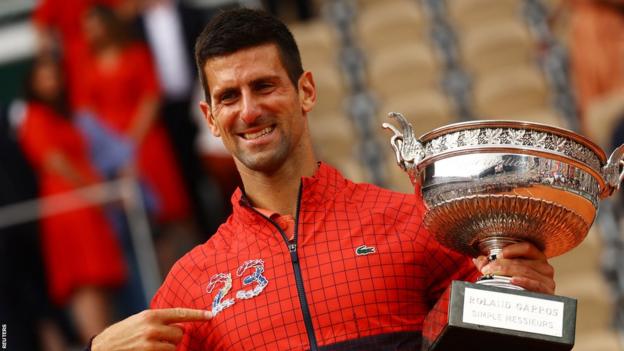 Novak Djokovic with the number 23 embroidered on his top - the number of Grand Slams he has now won - and the French Open trophy
