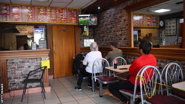 Fans watching the game in a cafe near Watford's stadium