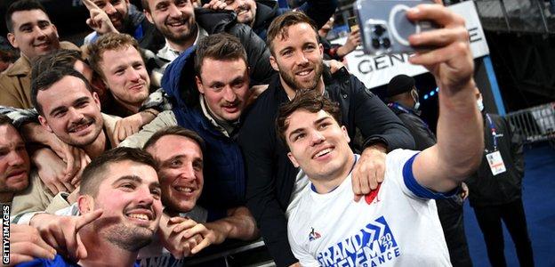 Gregory Alldritt and Antoine Dupont share selfies with fans after the final whistle