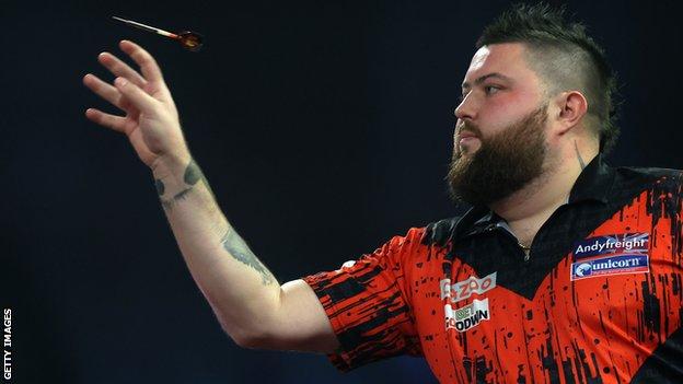 Michael Smith throws a dart