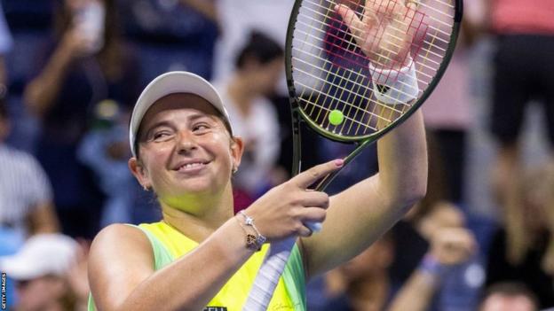 Jelena Ostapenko claps her racquet to the US Open crowd after beating Iga Swiatek