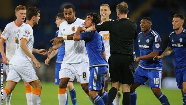 Fabio Da Silva of Cardiff City is restrained by players and the referee as he challenges Alex Bruce of Hull City