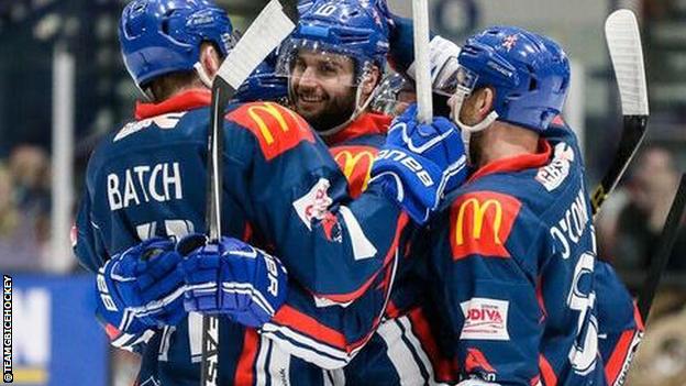 Great Britain ice hockey members celebrate a goal
