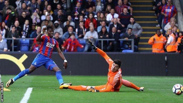 Wilfried Zaha scores past Chelsea's Thibaut Courtois to give Crystal Palace their first Premier League win of the season