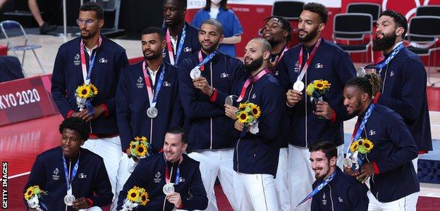 France's men's basketball team pose with silver medals from the Tokyo 2020 Olympics