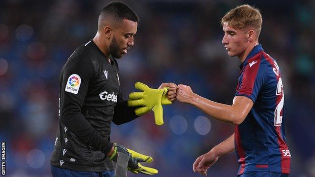 Red-carded Levante keeper Aitor Fernandez hands the gloves to defender Ruben Vezo