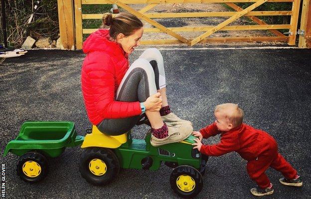 helen glover being pushed on a toy tractor