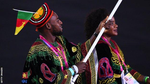 Emmanuel Eseme (left) carries Cameroon's flag at the Birmingham 2022 opening ceremony