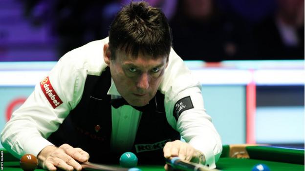 Jimmy White plays a shot with the rest