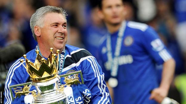 Carlo Ancelotti, then the manager of Chelsea, holds the Premier League trophy in 2010 with Frank Lampard out of focus in the background