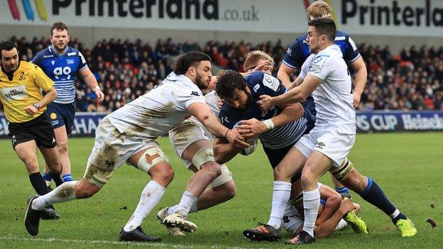 Lood de Jager is tackled during the Heineken Champions Cup match between Sale Sharks and Ospreys