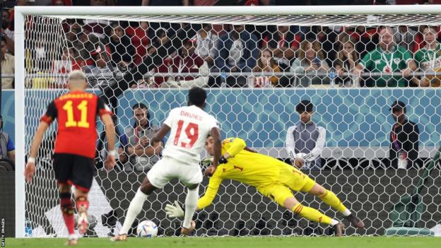 Thibaut Courtois of Belgium saves the penalty taken by Alphonso Davies of Canada