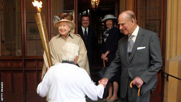 Prince Phillip and the Queen welcome the Olympic torch to Windsor Castle in 2012