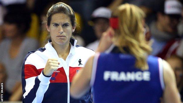 Amelie Mauresmo clenches her first in encouragement while France Fed Cup captain