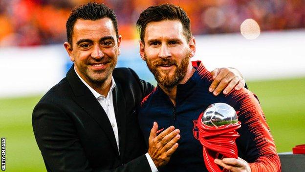 Xavi pose aux côtés de Lionel Messi