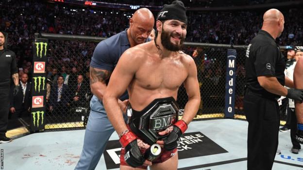 Dwayne "the Rock" Johnson puts the BMF title around the waist of Jorge Masvidal