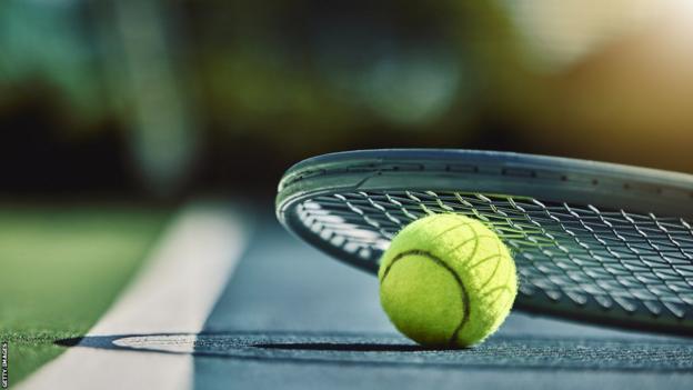 A tennis racquet and ball