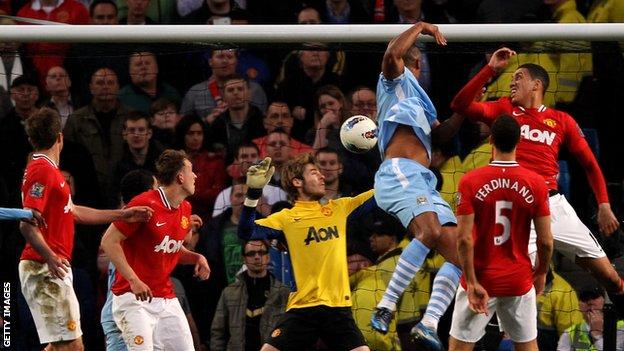 Manchester City's Vincent Kompany heads past Manchester United's David de Gea