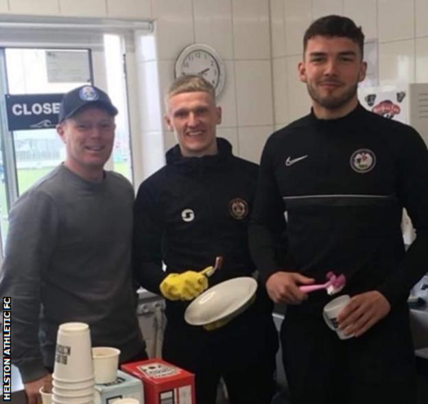 Players Josh Storey (right) and Tyler Elliott (centre) help Paul Osborne, who runs the Blues Kitchen which serves food to fans on matchdays, with the washing up