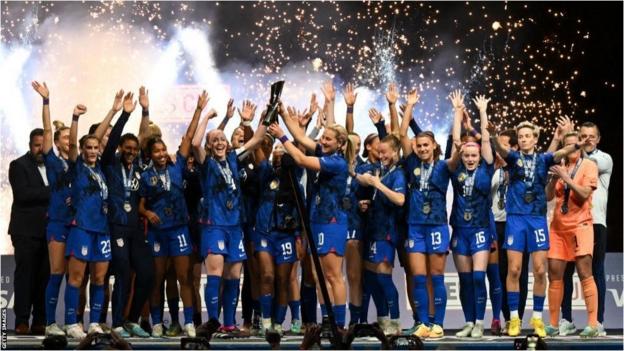 United States players celebrate on stage as they lift the trophy