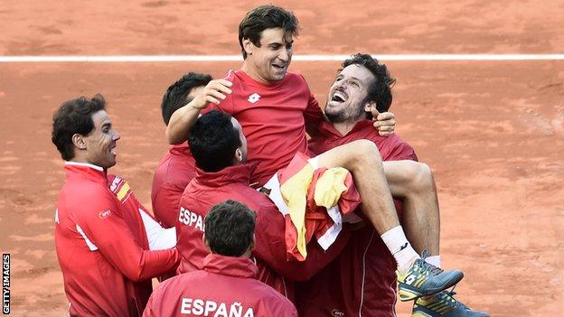 Spain's David Ferrer is held up by his team-mate after victory in the Davis Cup