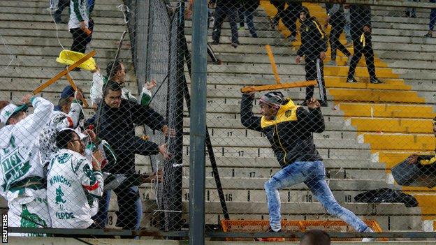 Fans of Palmeiras and Penarol fight at the end of their match.