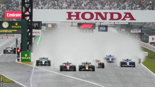 The cars leave a cloud of spray in their wake at the start of the Japanese Grand Prix
