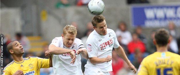 Garry Monk and Mark Gower challenge for a high ball