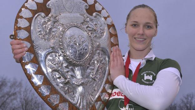 Randalstown captain Shelley Black lifts the Ulster Shield after her team's 4-2 penalty shoot-out win over Queen's University after the final at Stormont had ended in a 2-2 draw