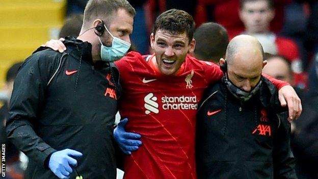 Liverpool left-back Andy Robertson is led off