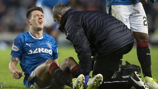 Ryan Jack winces in pain as he receives treatment for a knee injury sustained against Motherwell