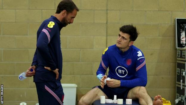 Harry Maguire speaks with England boss Gareth Southgate